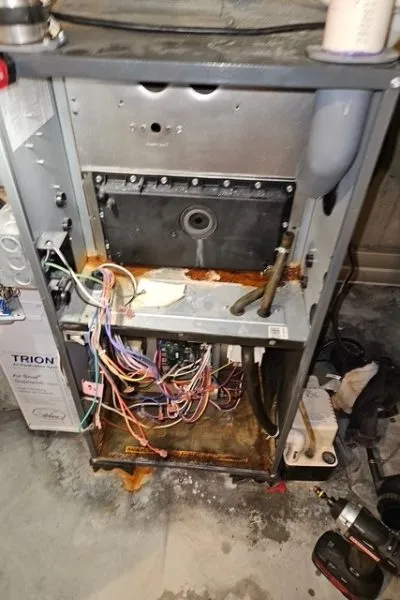 Rusty open furnace with exposed wiring