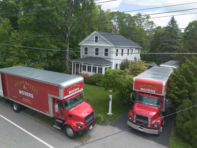 Two large trucks parked in front of a house.