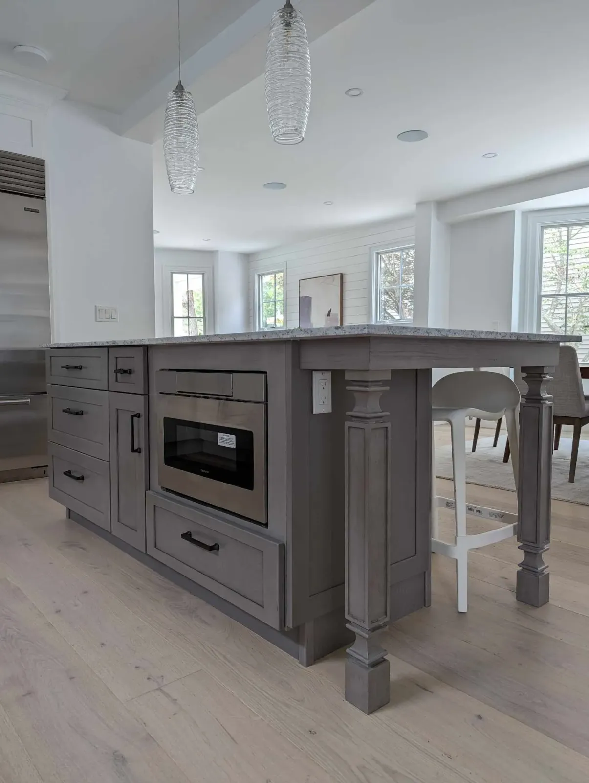 A kitchen with a large island and a microwave oven.