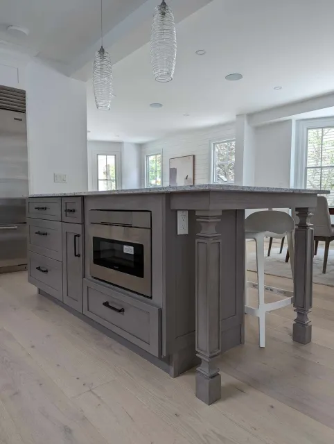 A kitchen with a large island and a microwave oven.