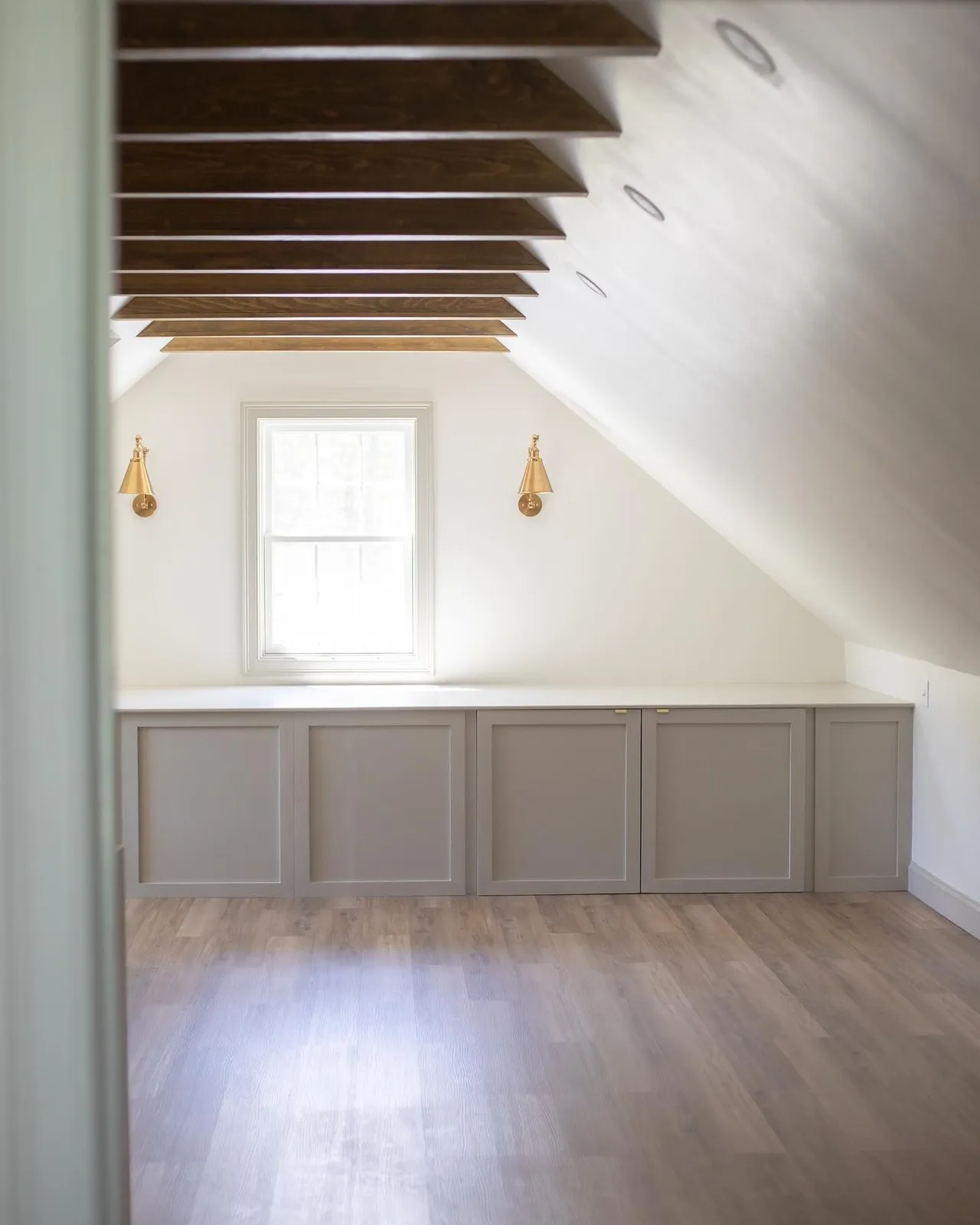 Attic build-out with exposed beams and built-in storage, after