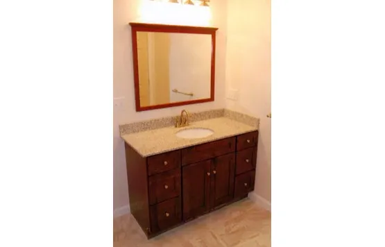 Bathroom vanity with framed mirror and stone top