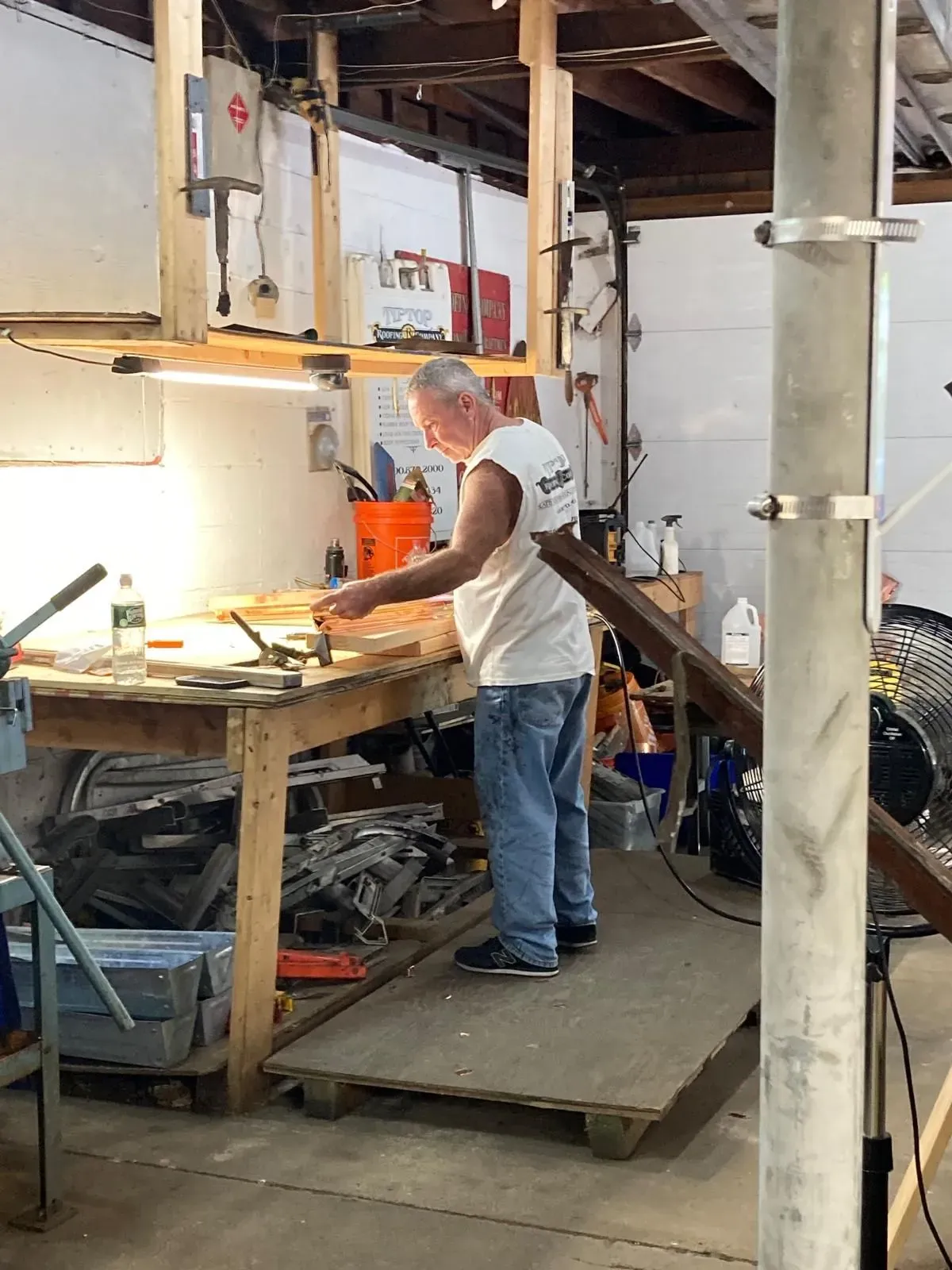 A man is working on a piece of wood in a workshop.
