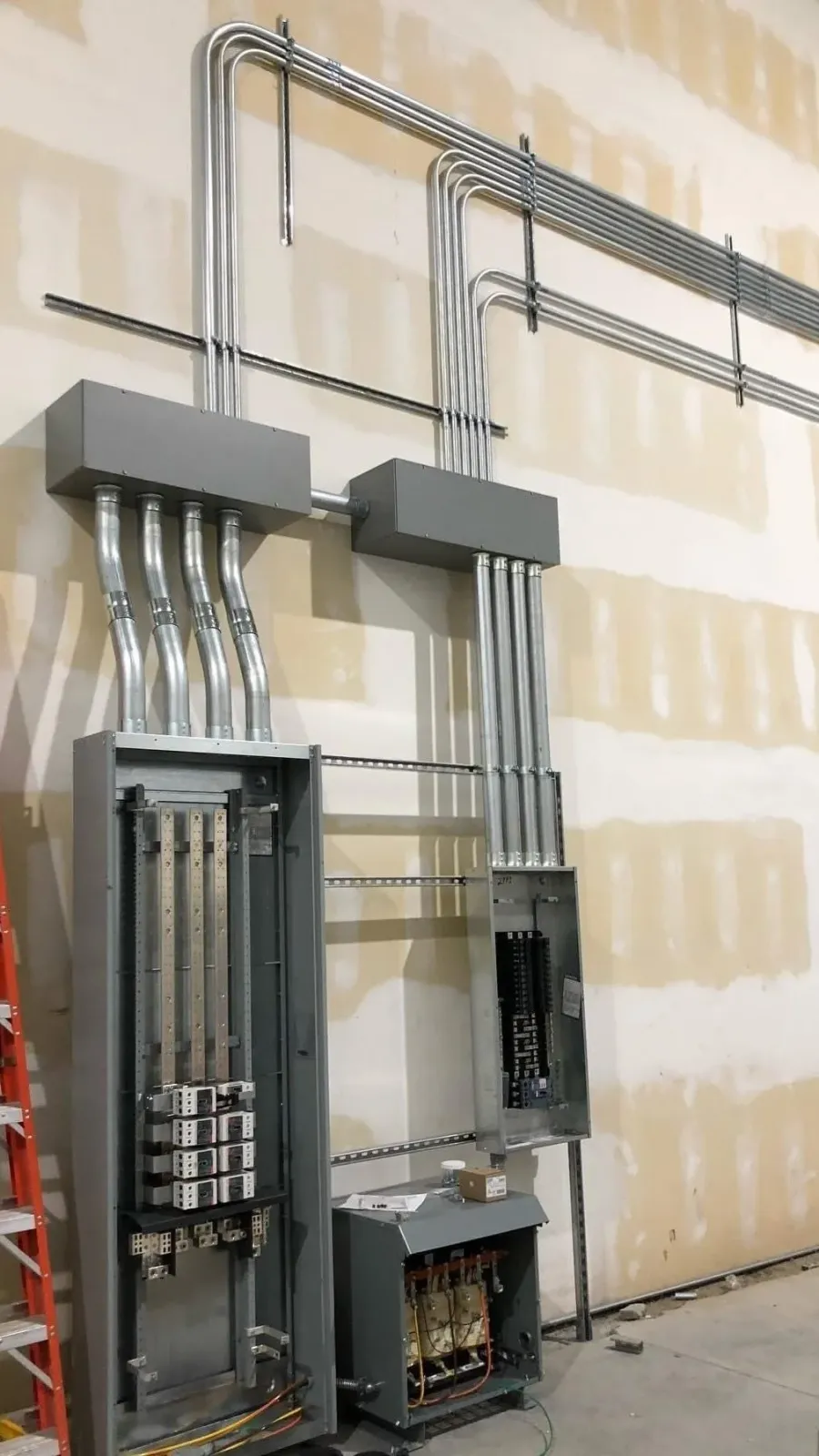 Electrical wiring and circuit breaker panels being installed on a building wall