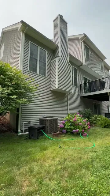 Technician soft washing the siding of a Connecticut home