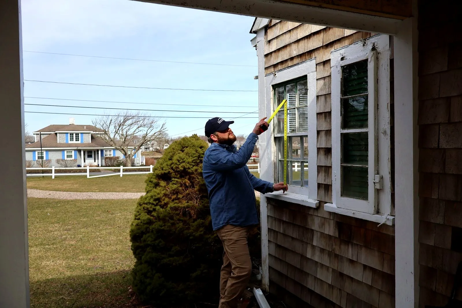 Measuring window for replacement on Cape Cod home