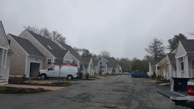 A row of houses are lined up on the side of a road.