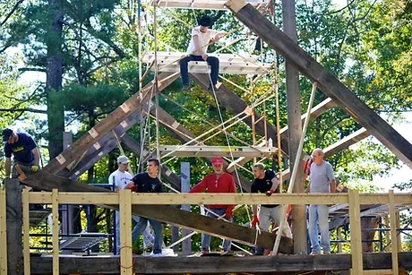 A team pic of Rand's Carpentry Service workers standing below an a-frame of a house being built.