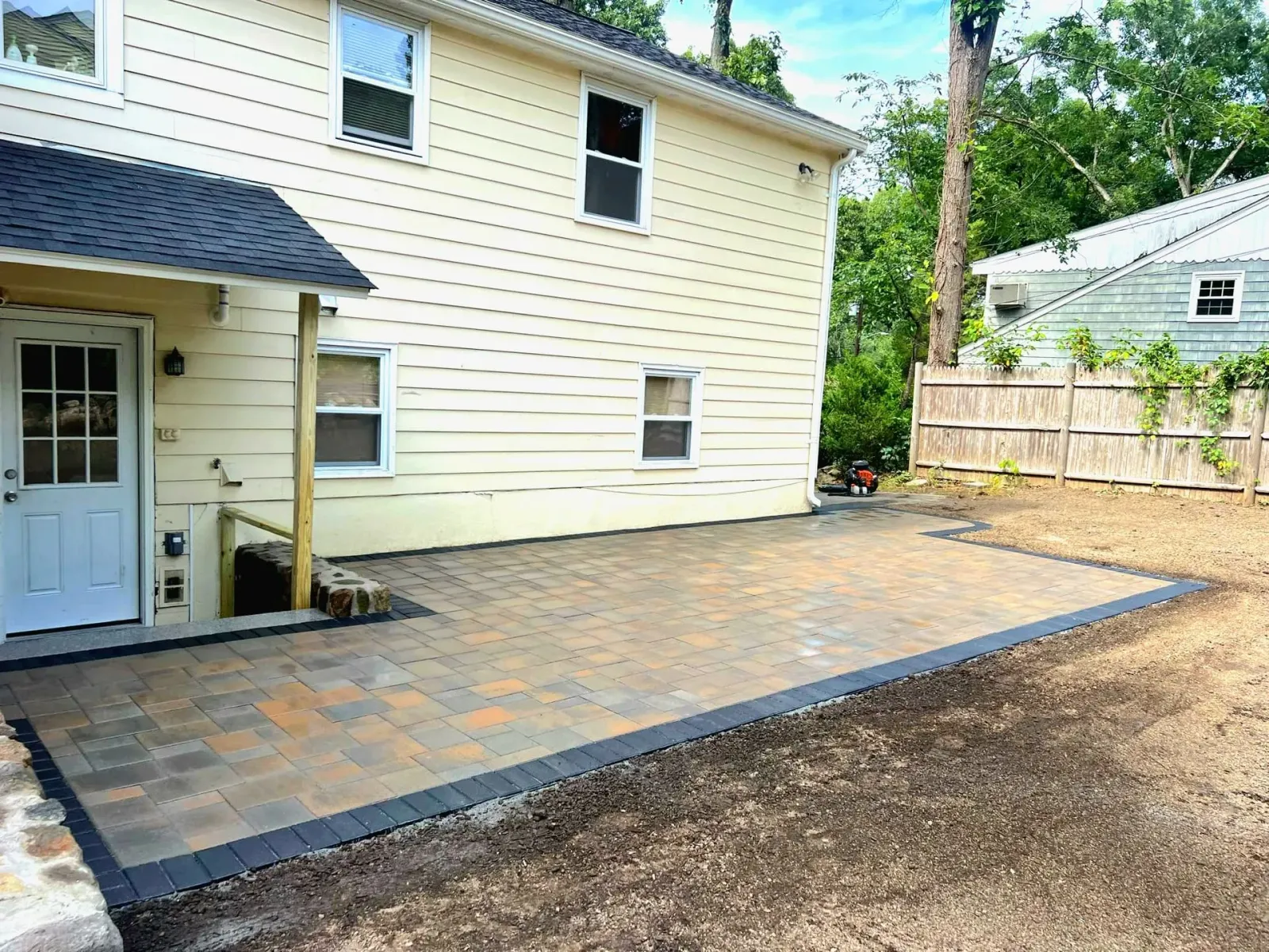 Stone patio with steps and retaining wall to expand useable yard space