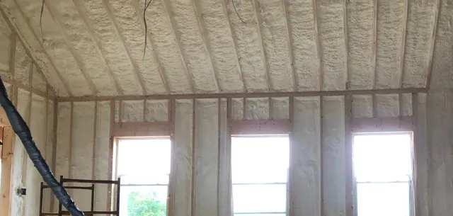 Vaulted cathedral ceiling and walls sprayed with foam insulation in a Maine home under construction