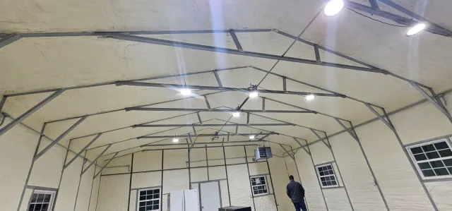 A man is standing in the middle of a large building.