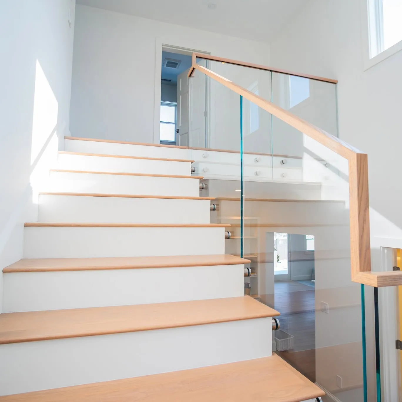 Open-riser stair with white oak treads and a glass railing