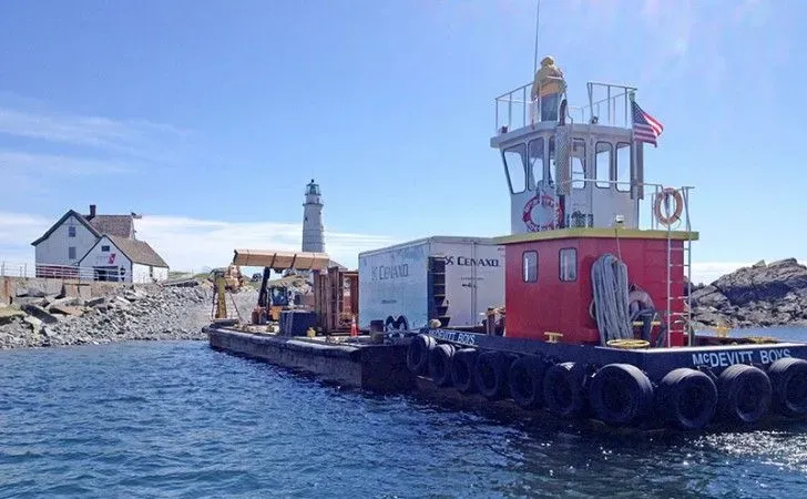 Offshore logistics at Boston Light — tugboat and barge delivering materials to Little Brewster Island for lighthouse restoration by Cenaxo