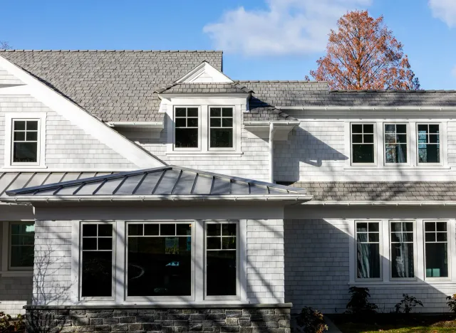 A white house with a gray roof and a lot of windows