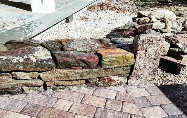 A brick walkway with rocks and gravel on the side.