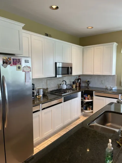Kitchen with white cabinets, granite counters, and stainless appliances in a Central Connecticut home by Riverbend Renovations