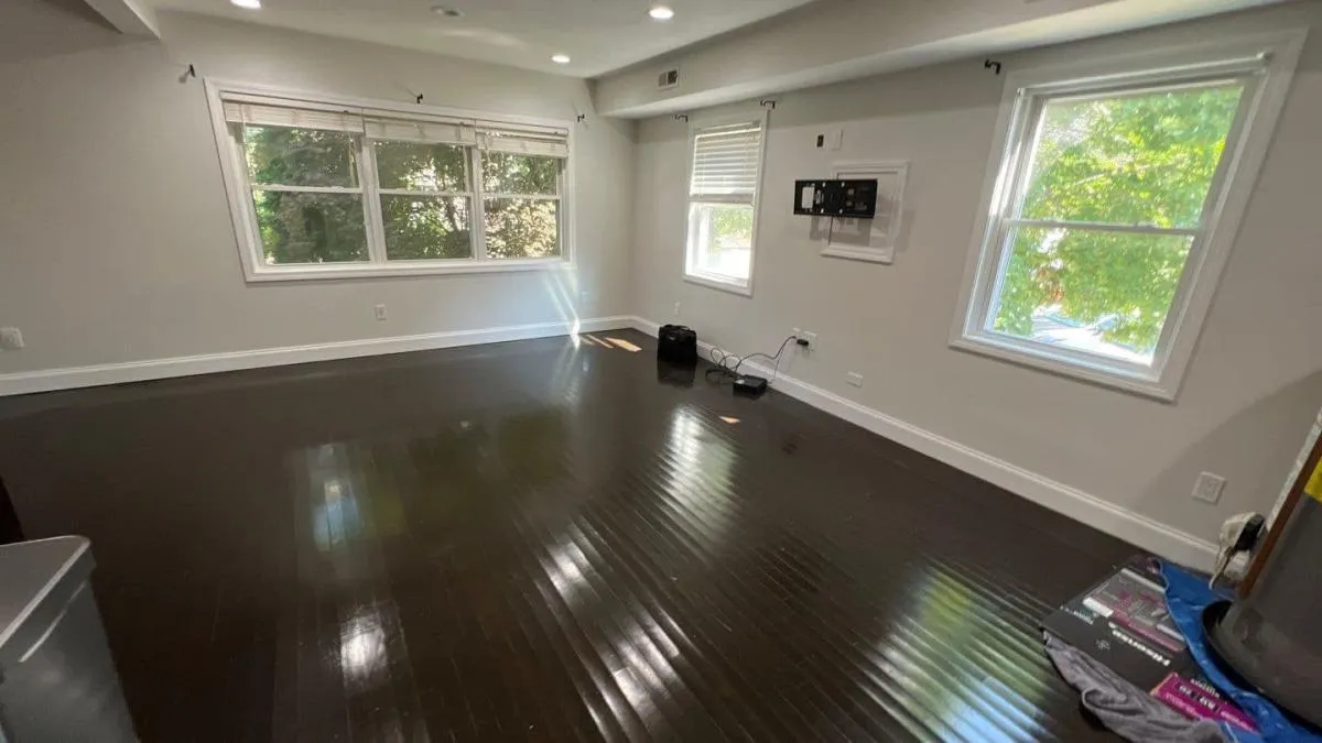 Finished residential room with dark wood flooring and cleared work area