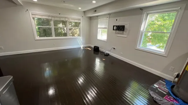 Finished residential room with dark wood flooring and cleared work area