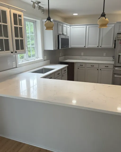 White quartz kitchen countertops with an undermount farmhouse sink in a New Hampshire kitchen