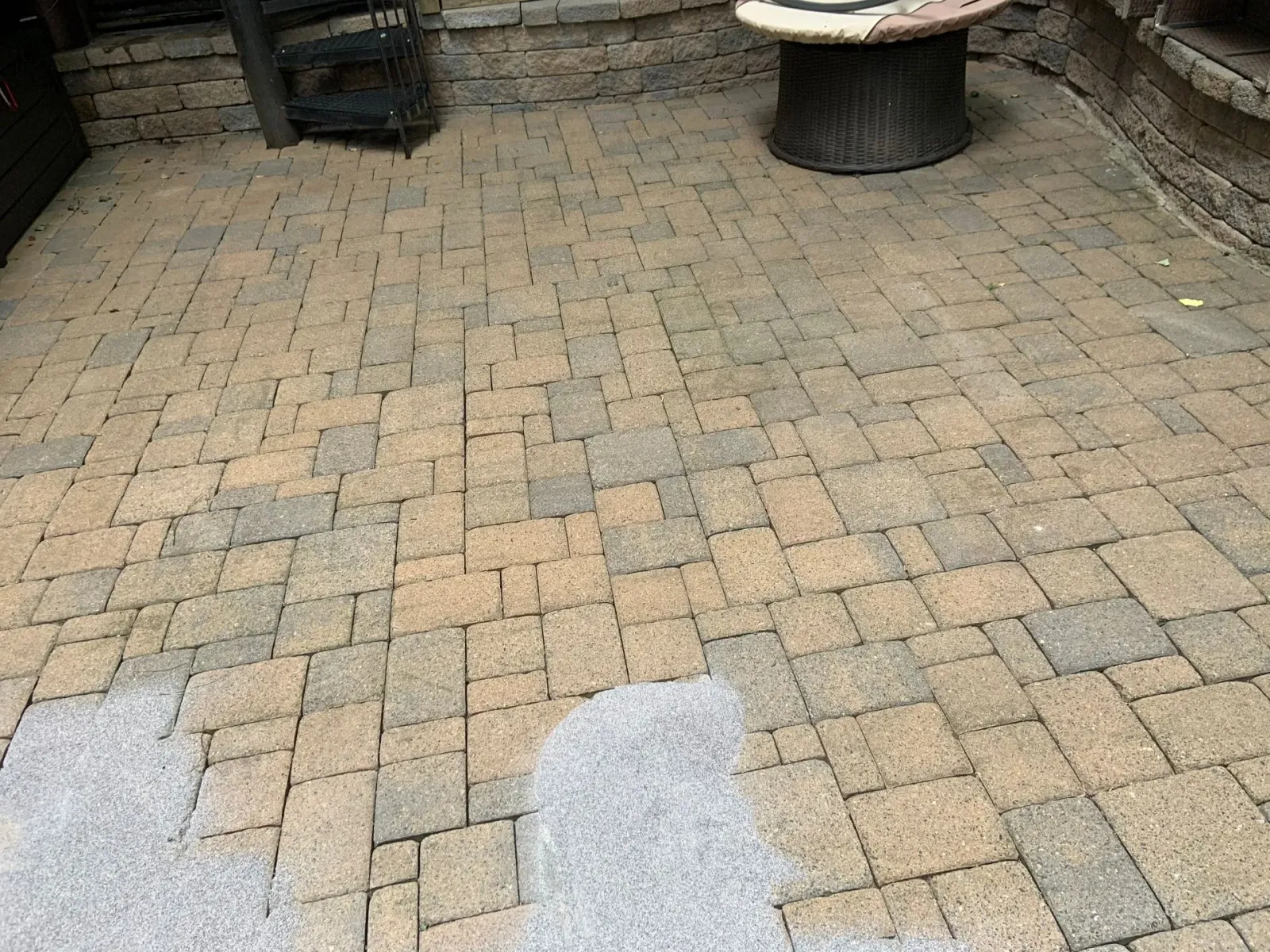 Brick patio with a small round table and wet patches near the foreground.