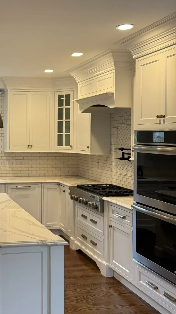Corner of a kitchen where the upper cabinetry, crown molding and hood meet the ceiling