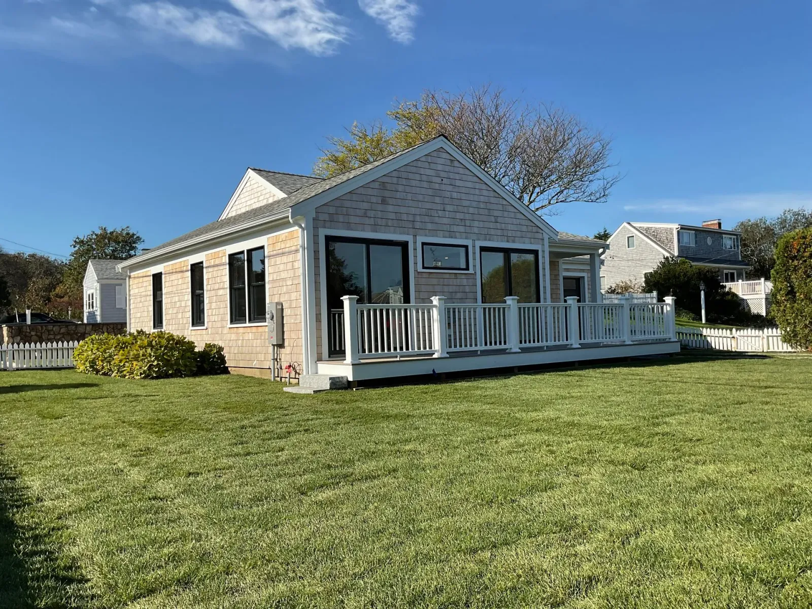A small house with a large lawn in front of it