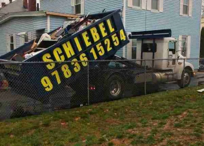 A home with a large roll off dumpster filled with trash and debris