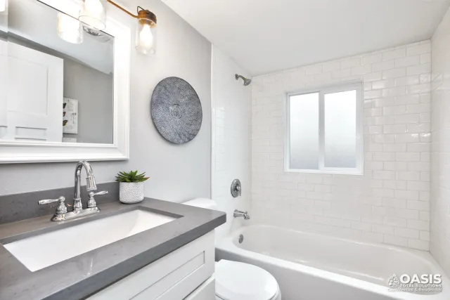 Completed bathroom with subway tile, tub, and new vanity