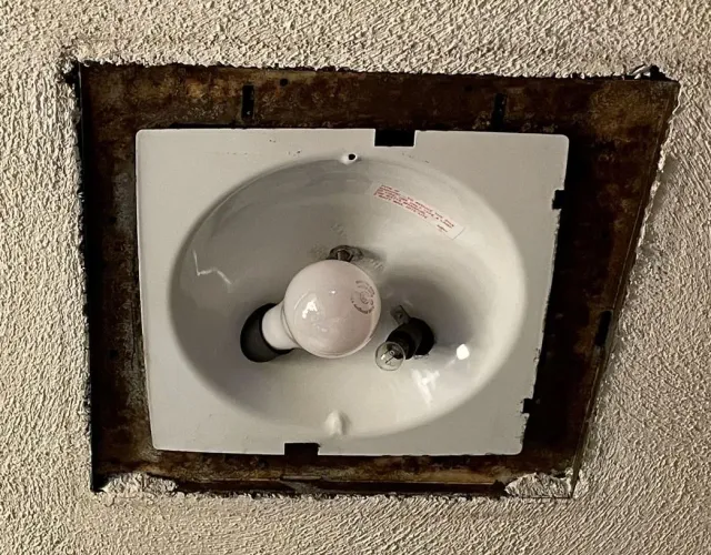A light bulb is sitting in a hole in the ceiling.