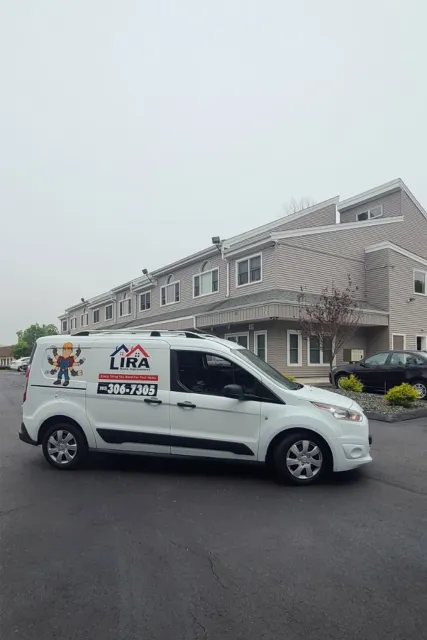 A company service van parked at a large residential complex following exterior multi-family painting work.