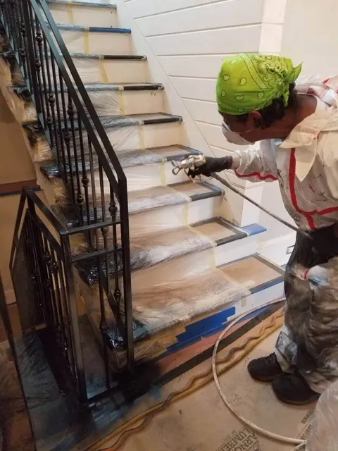 A man is spraying paint on a set of stairs.