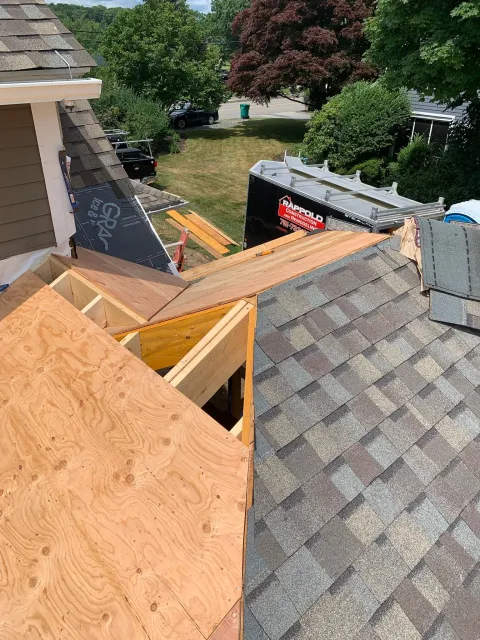 Roof construction site with plywood sheets and new roofing shingles, part of the roof is being replaced. Scituate, Norwell, Hanover, Hanson, Marshfield, South Shore. Massachusetts Local Construction Company.