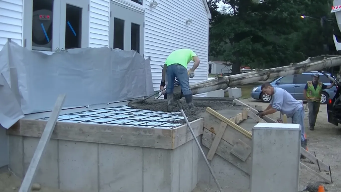 Precision grading and base preparation for concrete foundation with proper drainage setup