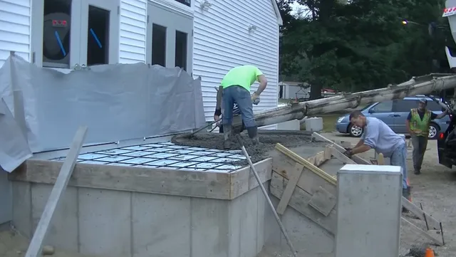 Precision grading and base preparation for concrete foundation with proper drainage setup