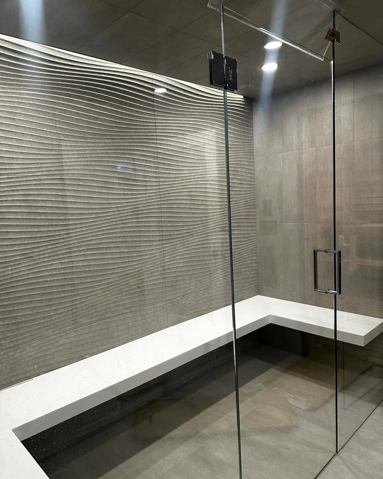 a bathroom with a bench and a glass door