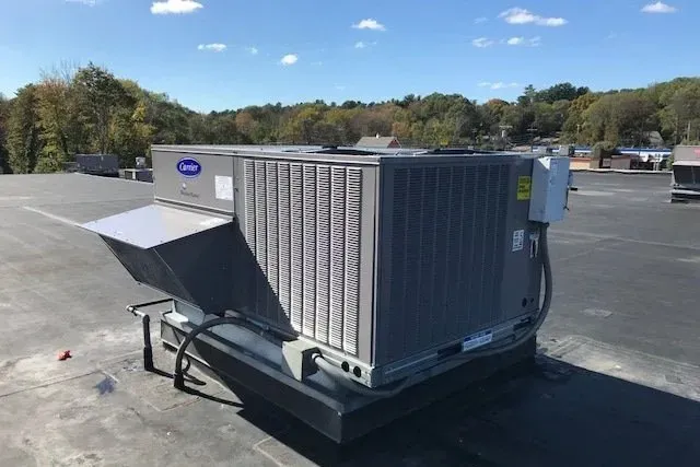 A large air conditioner is sitting on top of a roof.