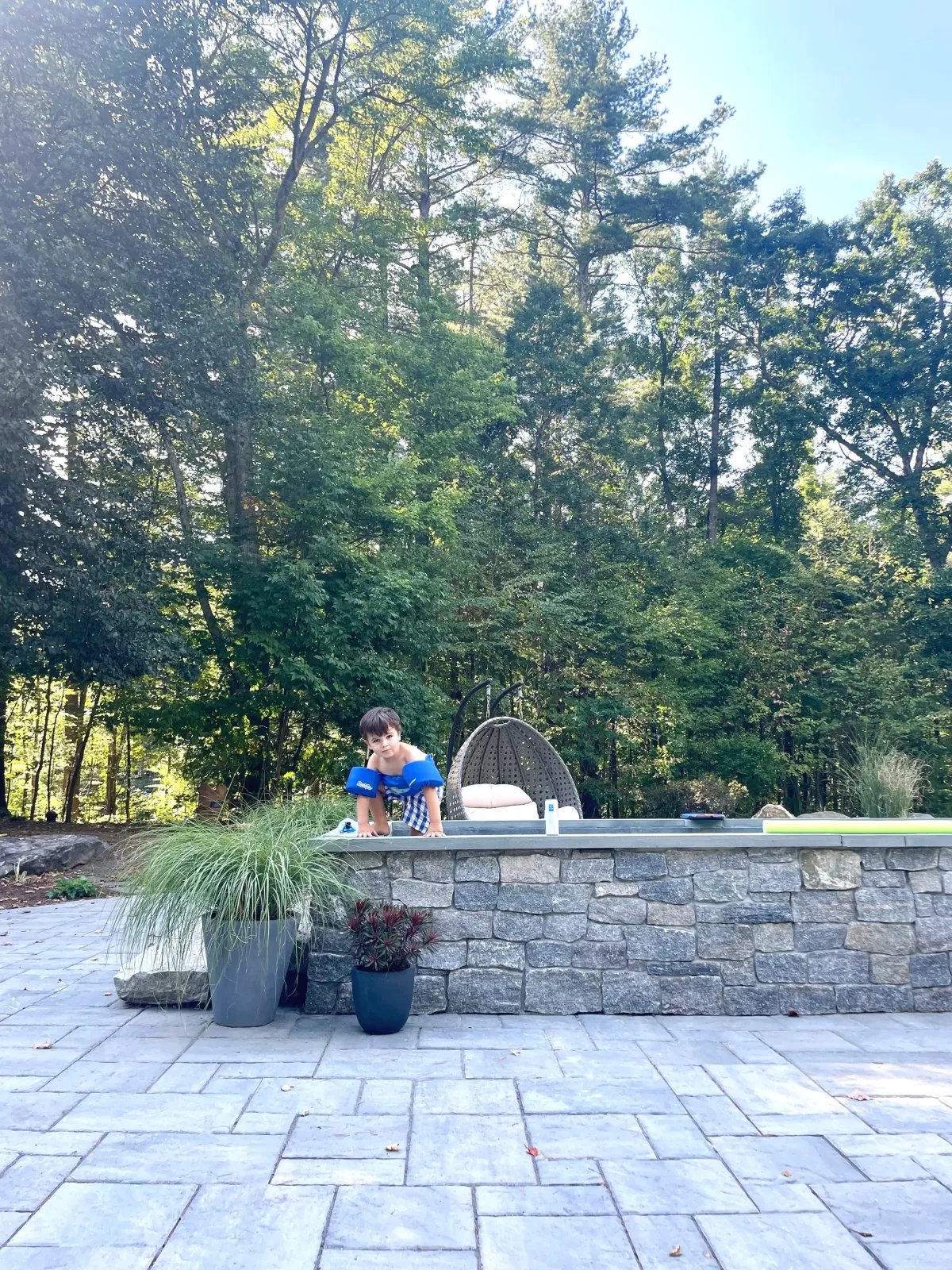 Natural stone steps and veneer with a large patio surrounding the pool