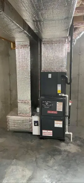 An air conditioner is sitting in a basement next to a wall.
