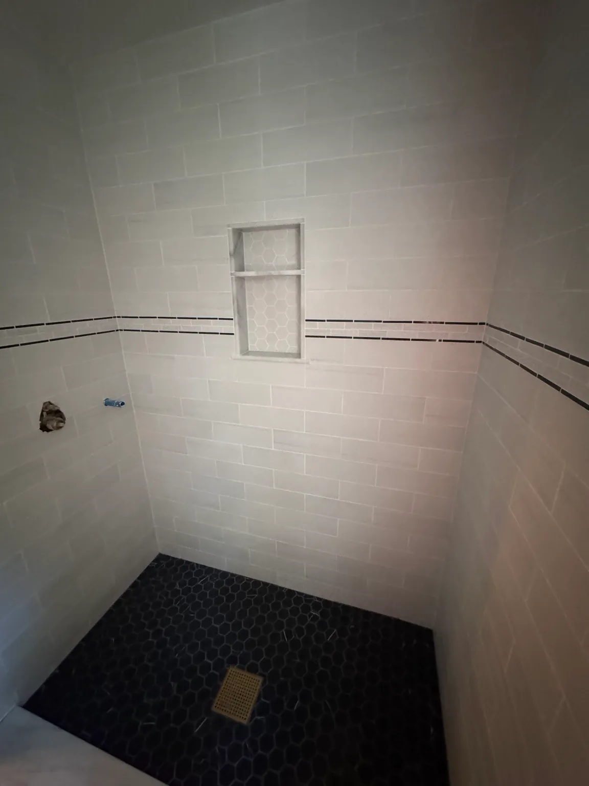 Custom tiled walk-in shower with inset storage niche