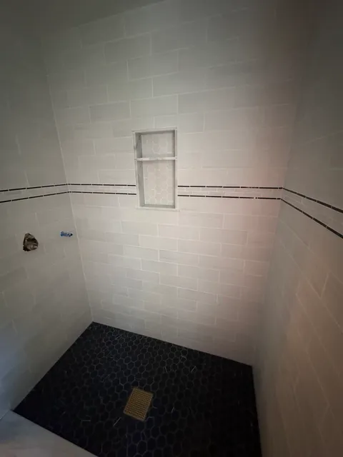 Custom tiled walk-in shower with inset storage niche