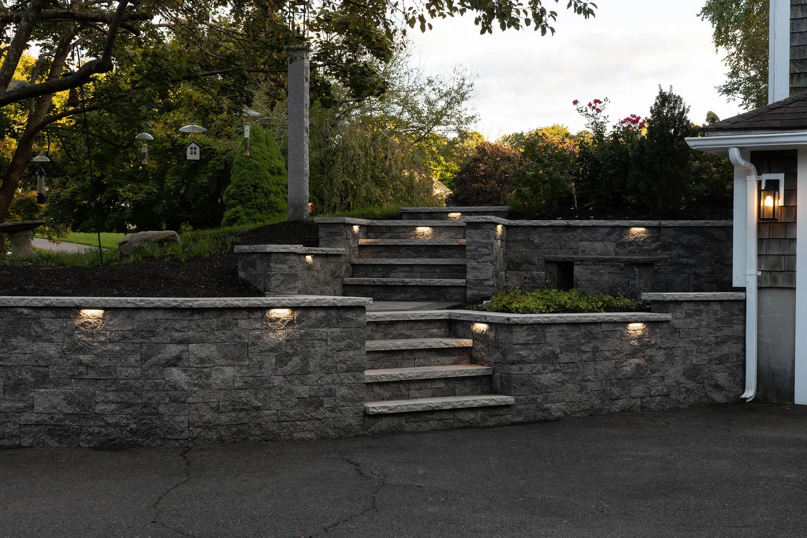 Front entrance stone retaining wall and steps with built in custom lighting installed by JS Hardscapes in Southeastern, MA.