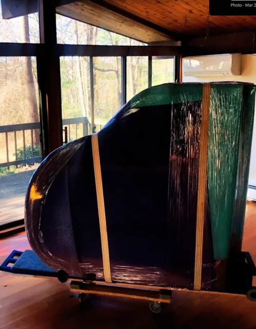 Photo of a grand piano strapped for moving.
