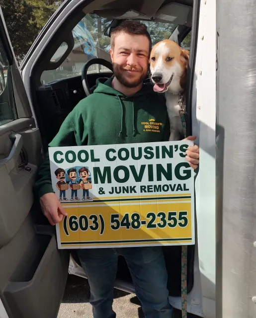 Man holding a Cool Cousin’s Moving sign with a dog in a van doorway, phone number visible