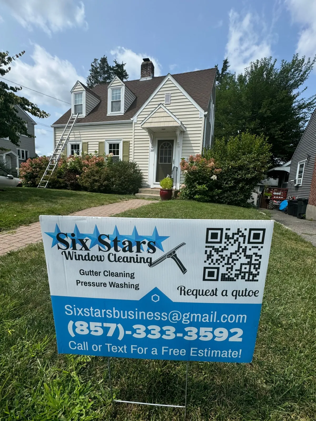 A sign for six stars window cleaning is in front of a house.