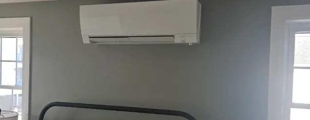 Mini-split installed neatly on a gray bedroom wall