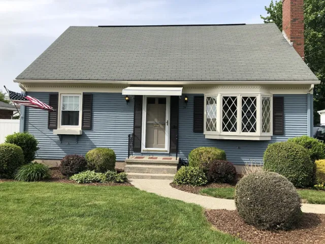 a blue house with a gray roof and black shutters