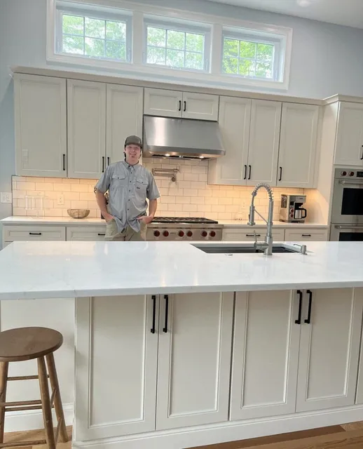 Person standing behind modern white kitchen island