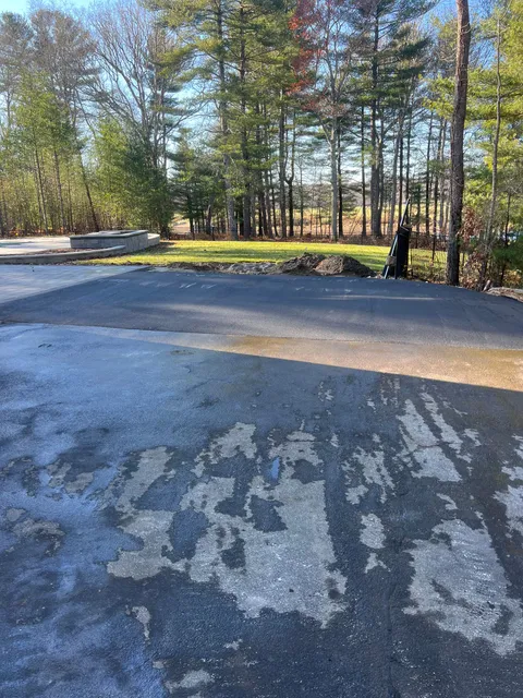 A parking lot with a lot of trees in the background.