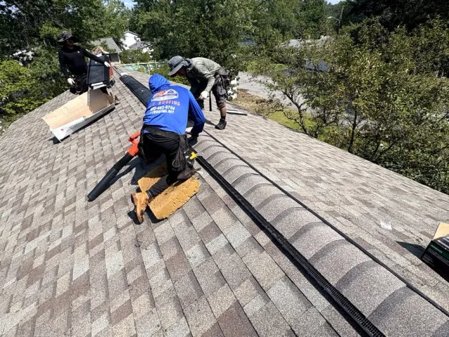 Roofer repairing shingles beside a skylight