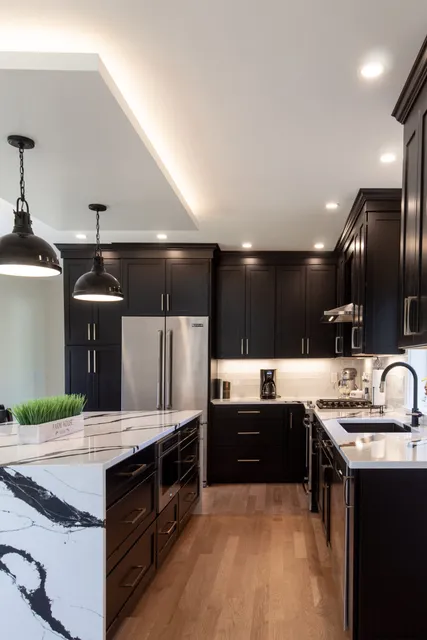 Dark cabinetry kitchen with marble island